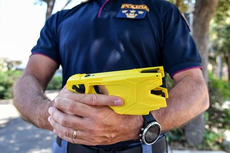 Un agente di polizia tiene impugna un taser nel Centro Nazionale di specializzazione e perfezionamento nel tiro, dove si svolge laddestramento degli operatori di Polizia alluso del taser, Nettuno, 3 luglio 2019.
ANSA/ALESSANDRO DI MEO