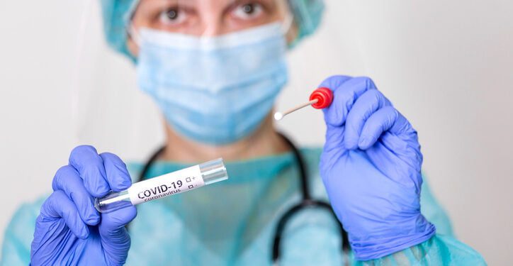 Female caucasian doctor holding a swab collection stick, nasal and oral specimen swabbing , patient PCR testing procedure appointment, Coronavirus COVID-19 global pandemic crisis